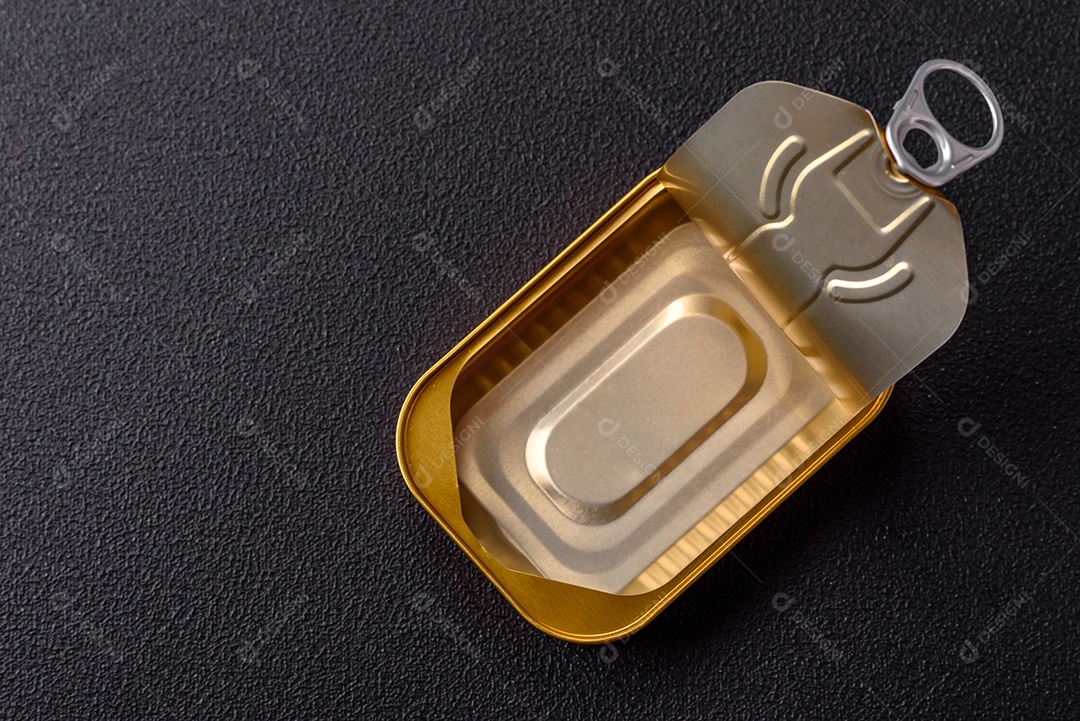 Lata metálica com carne ou peixe enlatado com chave para abri-lo sobre um fundo escuro de concreto