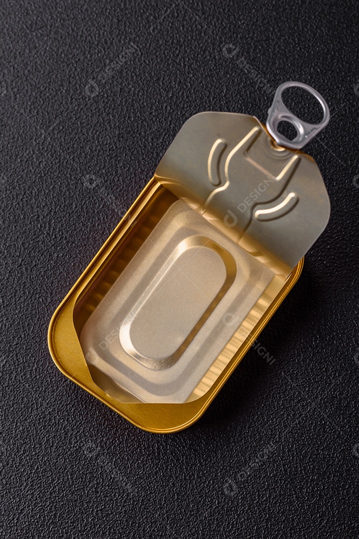 Lata metálica com carne ou peixe enlatado com chave para abri-lo sobre um fundo escuro de concreto