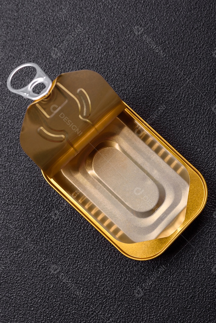 Lata metálica com carne ou peixe enlatado com chave para abri-lo sobre um fundo escuro de concreto