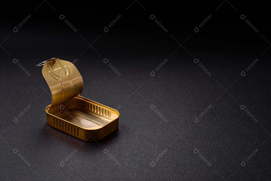 Lata metálica com carne ou peixe enlatado com chave para abri-lo sobre um fundo escuro de concreto