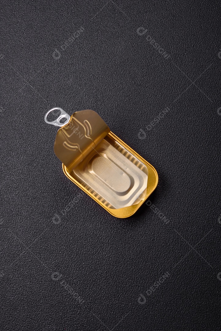 Lata metálica com carne ou peixe enlatado com chave para abri-lo sobre um fundo escuro de concreto