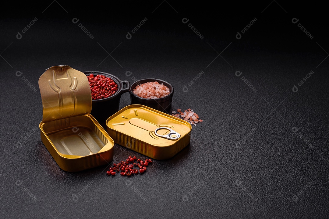 Lata metálica com carne ou peixe enlatado com chave para abri-lo sobre um fundo escuro de concreto