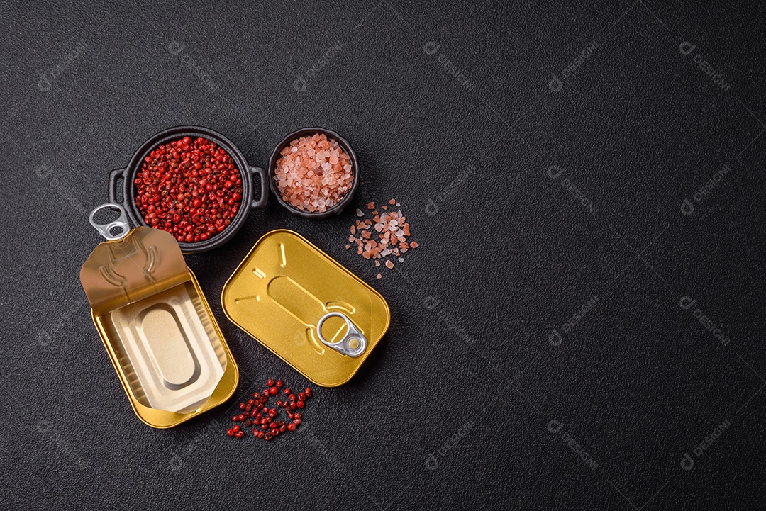 Lata metálica com carne ou peixe enlatado com chave para abri-lo sobre um fundo escuro de concreto