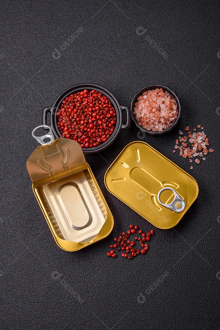 Lata metálica com carne ou peixe enlatado com chave para abri-lo sobre um fundo escuro de concreto