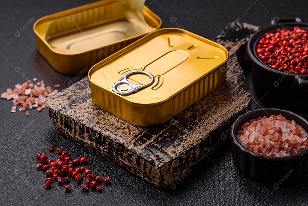 Lata metálica com carne ou peixe enlatado com chave para abri-lo sobre um fundo escuro de concreto