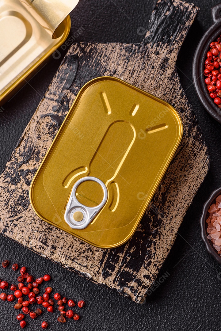 Lata metálica com carne ou peixe enlatado com chave para abri-lo sobre um fundo escuro de concreto