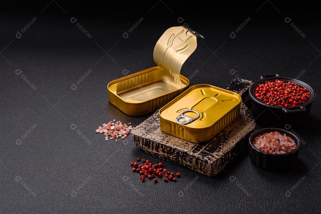 Lata metálica com carne ou peixe enlatado com chave para abri-lo sobre um fundo escuro de concreto