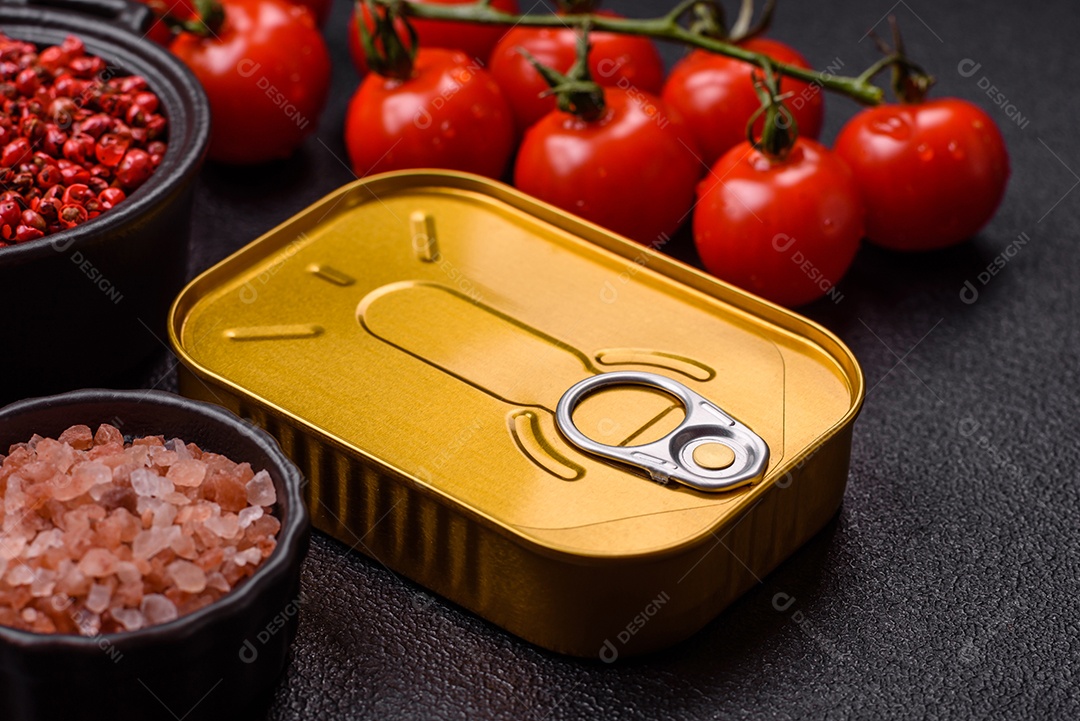 Lata metálica com carne ou peixe enlatado com chave para abri-lo sobre um fundo escuro de concreto