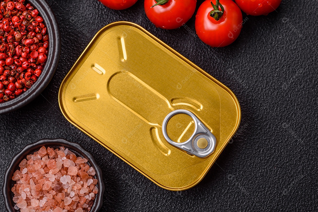 Lata metálica com carne ou peixe enlatado com chave para abri-lo sobre um fundo escuro de concreto