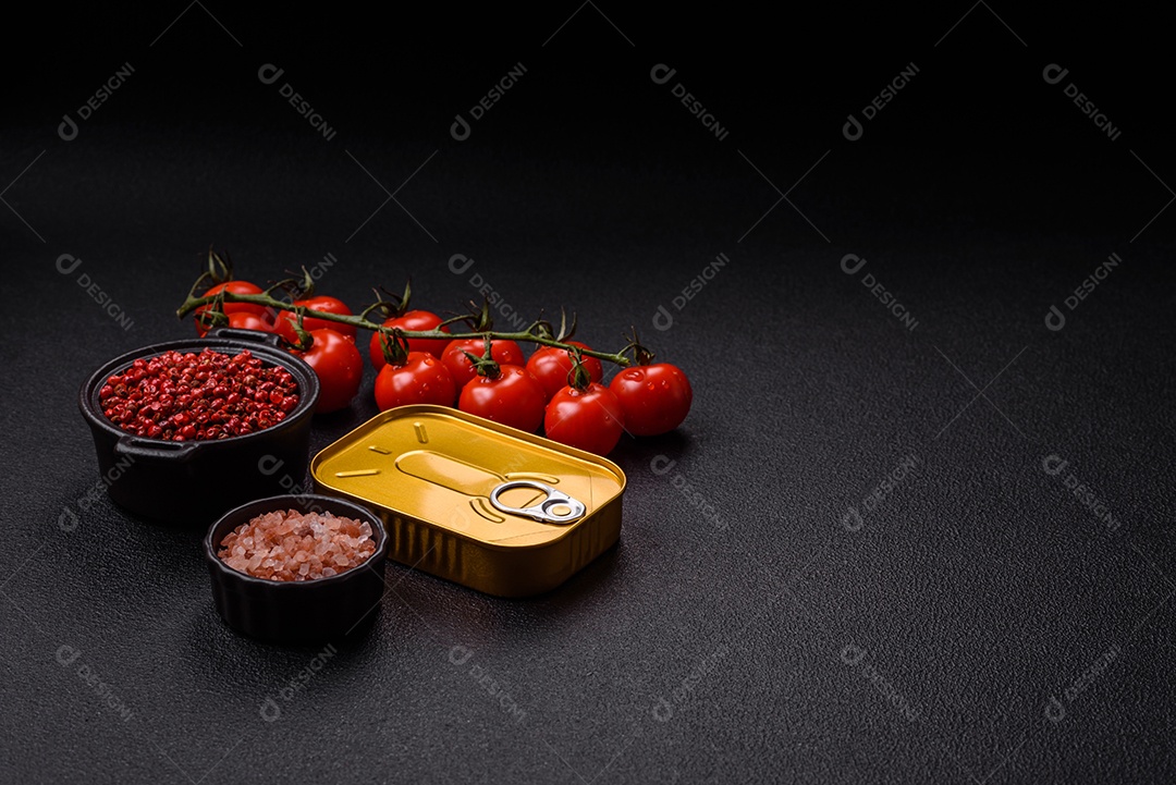 Lata metálica com carne ou peixe enlatado com chave para abri-lo sobre um fundo escuro de concreto