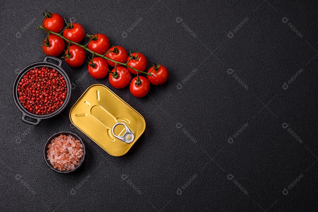 Lata metálica com carne ou peixe enlatado com chave para abri-lo sobre um fundo escuro de concreto