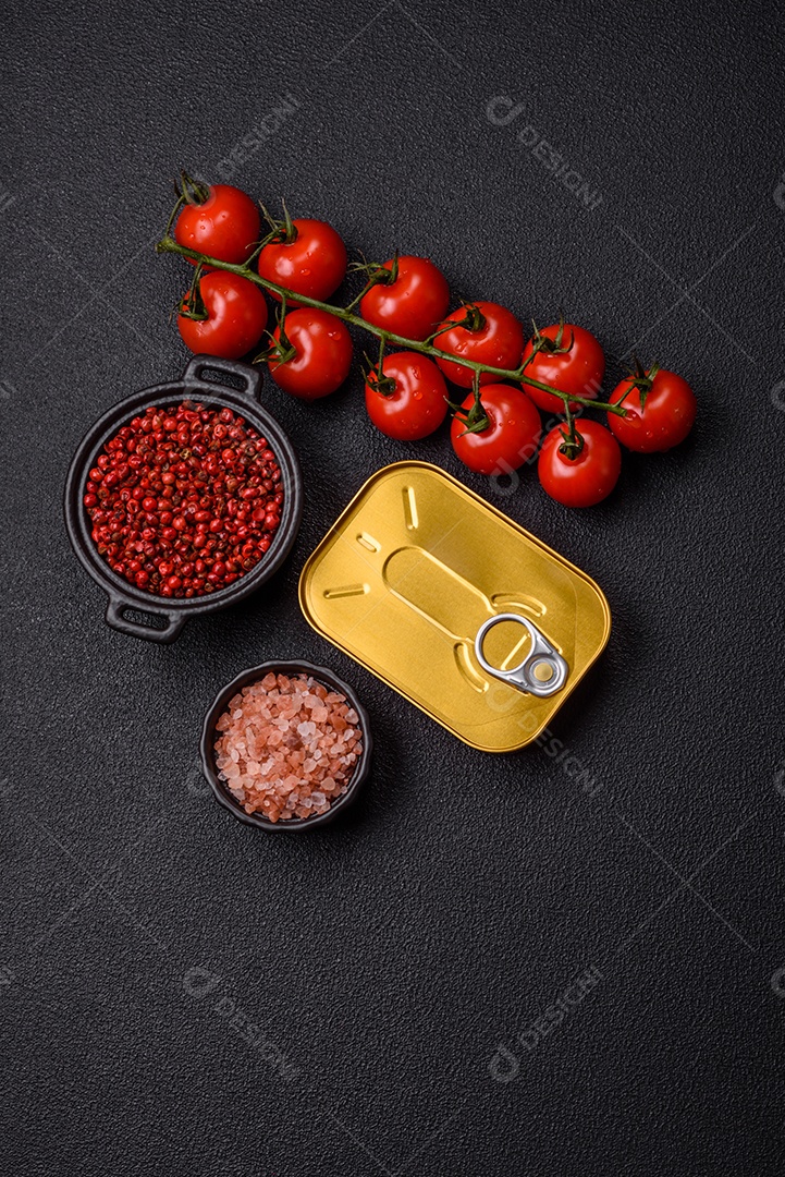 Lata metálica com carne ou peixe enlatado com chave para abri-lo sobre um fundo escuro de concreto