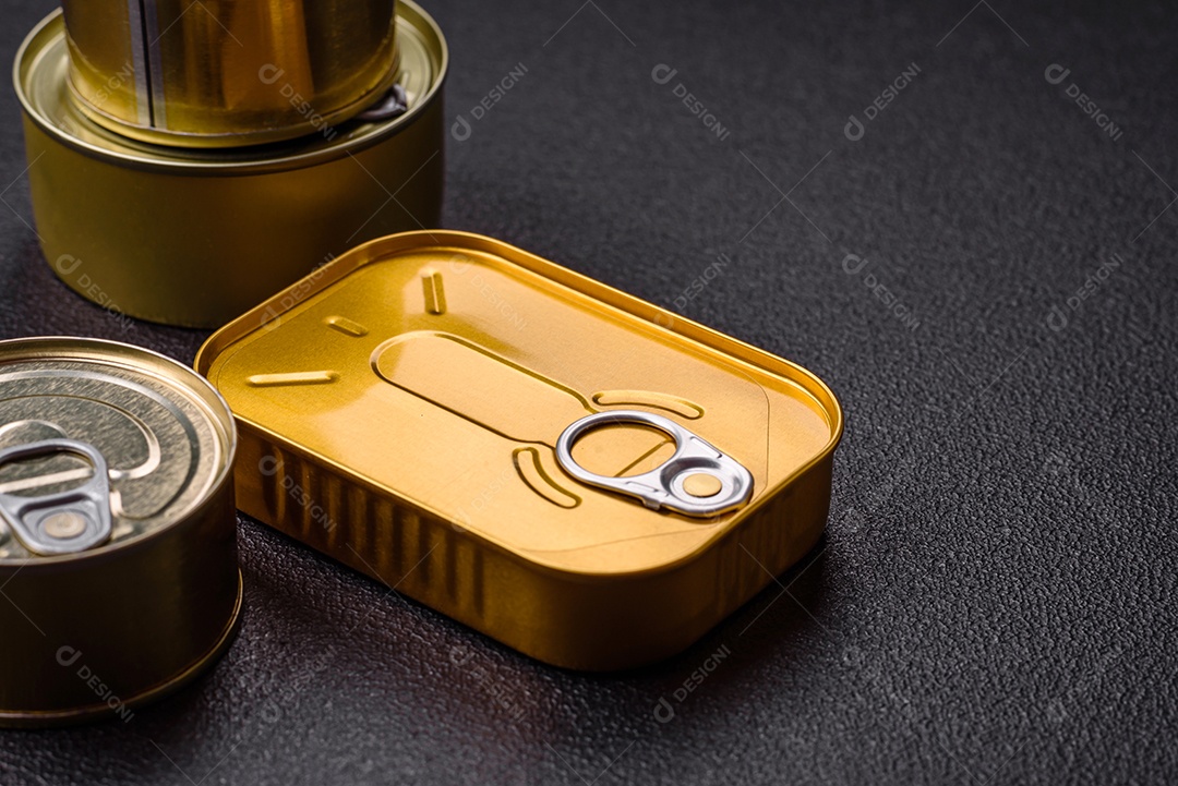 Lata metálica com carne ou peixe enlatado com chave para abri-lo sobre um fundo escuro de concreto