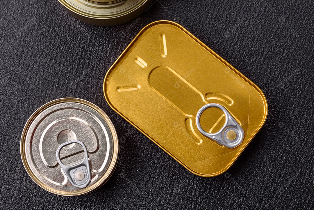 Lata metálica com carne ou peixe enlatado com chave para abri-lo sobre um fundo escuro de concreto
