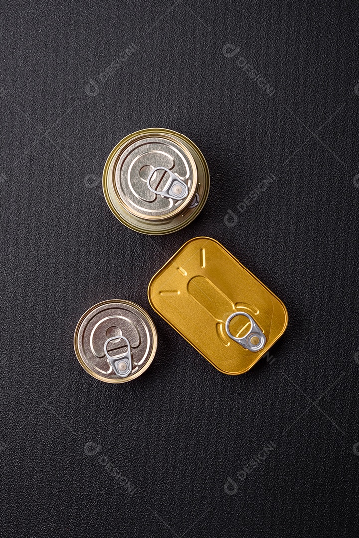 Lata metálica com carne ou peixe enlatado com chave para abri-lo sobre um fundo escuro de concreto