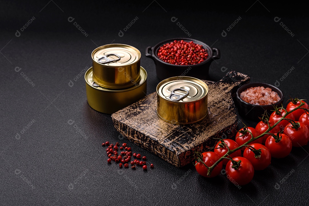 Lata metálica com carne ou peixe enlatado com chave para abri-lo sobre um fundo escuro de concreto