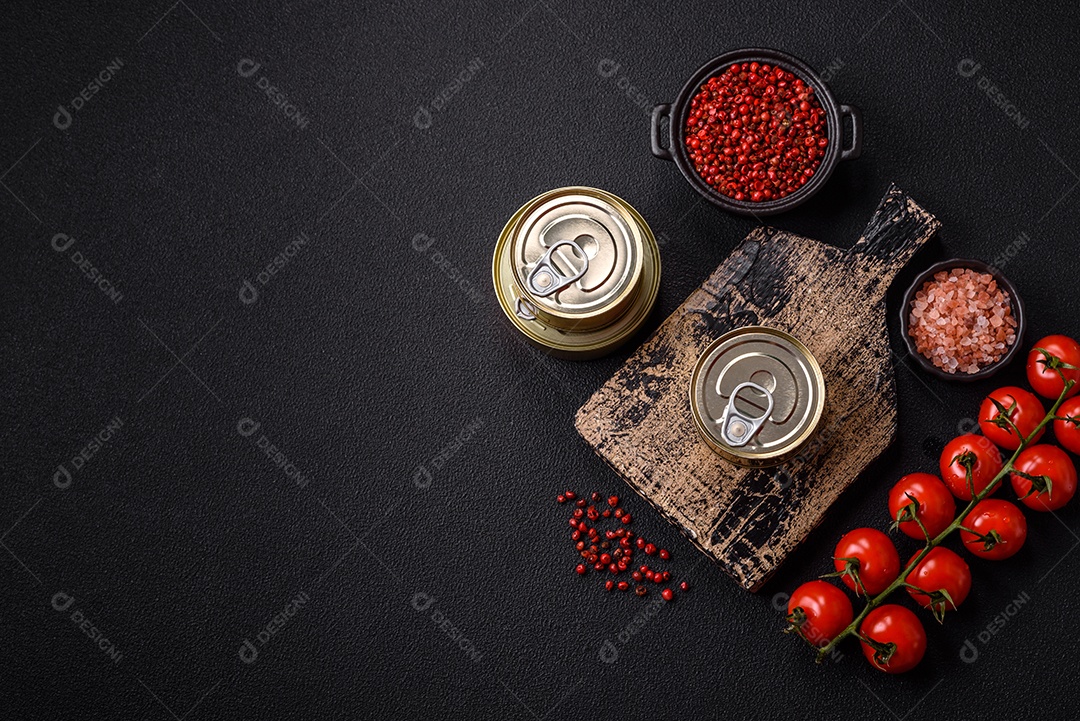 Lata metálica com carne ou peixe enlatado com chave para abri-lo sobre um fundo escuro de concreto