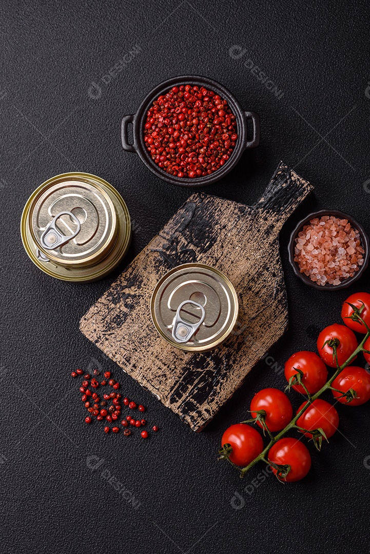 Lata metálica com carne ou peixe enlatado com chave para abri-lo sobre um fundo escuro de concreto