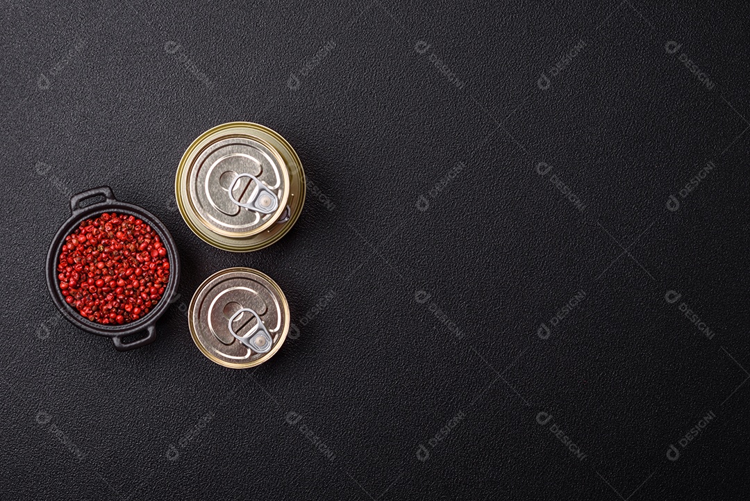 Lata metálica com carne ou peixe enlatado com chave para abri-lo sobre um fundo escuro de concreto