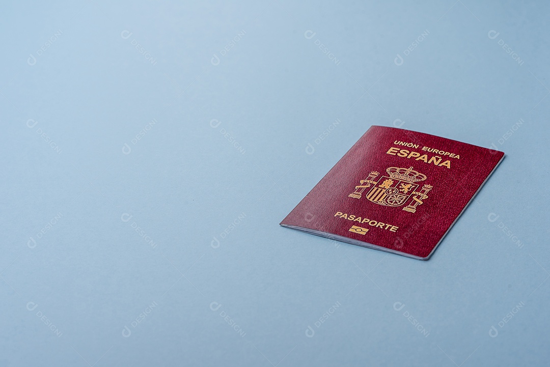 Passaporte internacional em papel físico de cidadão espanhol sobre fundo azul