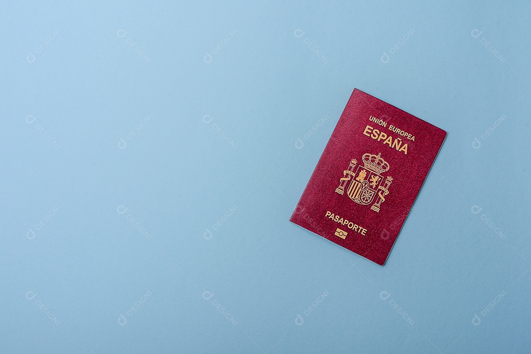 Passaporte internacional em papel físico de cidadão espanhol sobre fundo azul