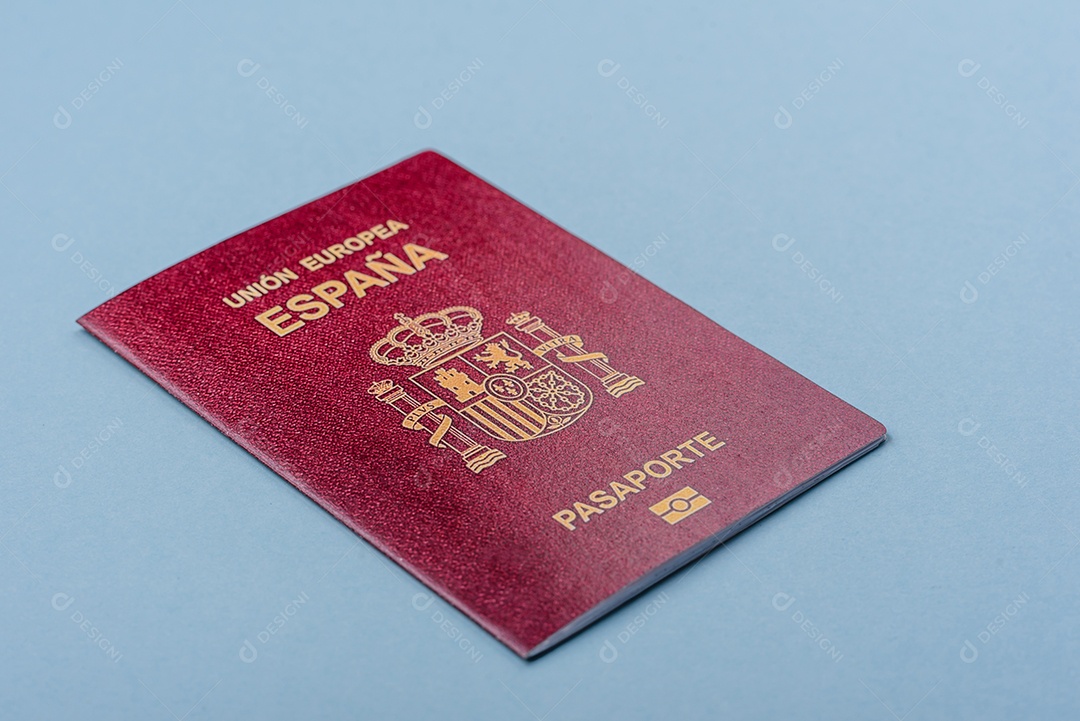 Passaporte internacional em papel físico de cidadão espanhol sobre fundo azul