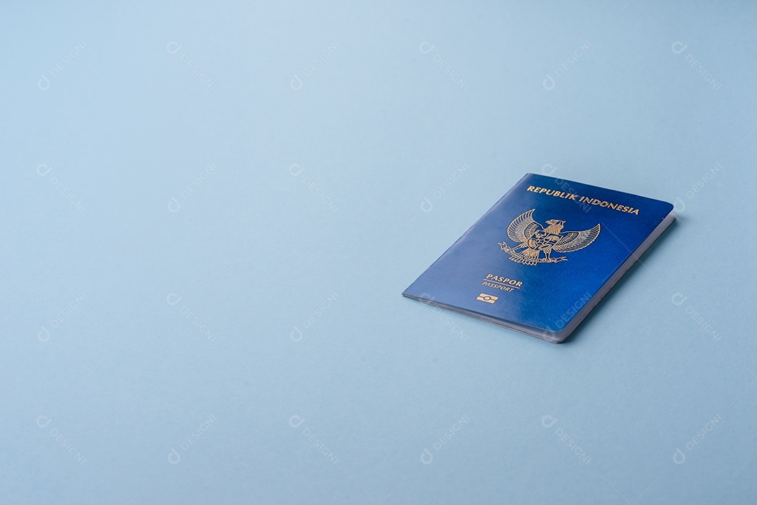 Passaporte internacional em papel físico de cidadão indonésio sobre fundo azul