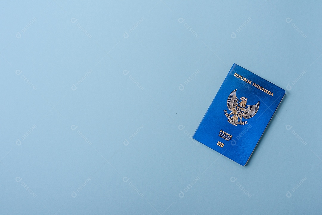 Passaporte internacional em papel físico de cidadão indonésio sobre fundo azul