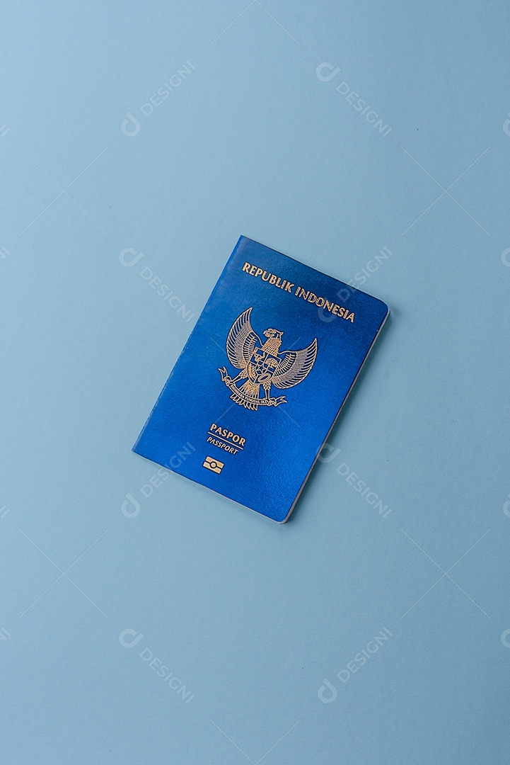 Passaporte internacional em papel físico de cidadão indonésio sobre fundo azul