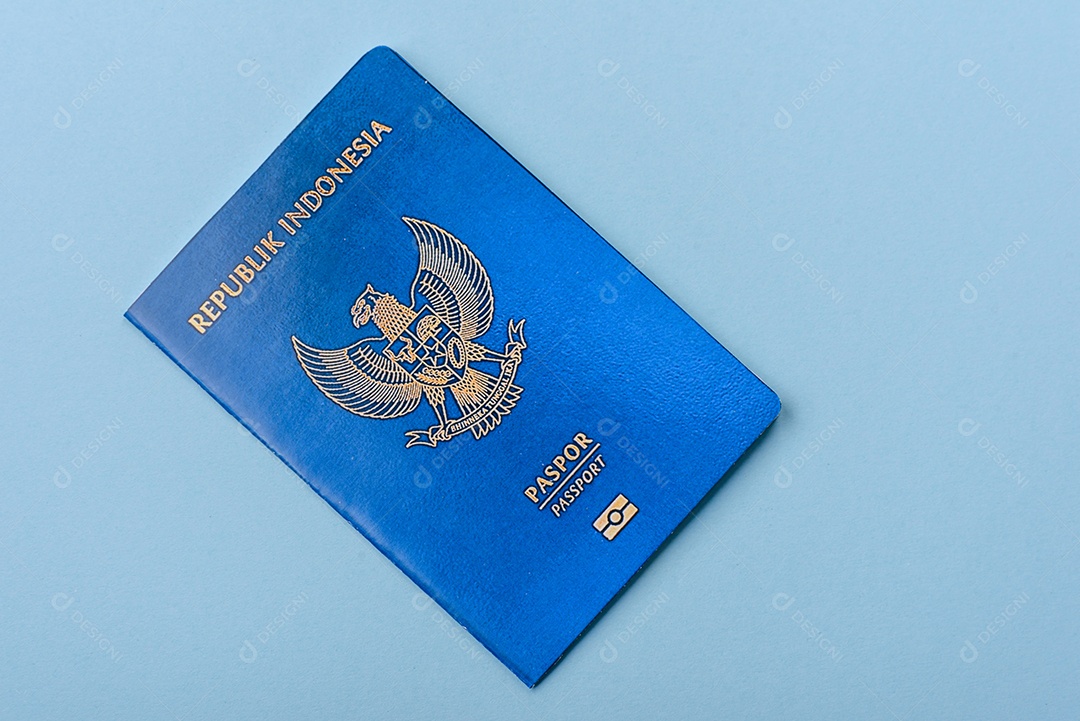 Passaporte internacional em papel físico de cidadão indonésio sobre fundo azul