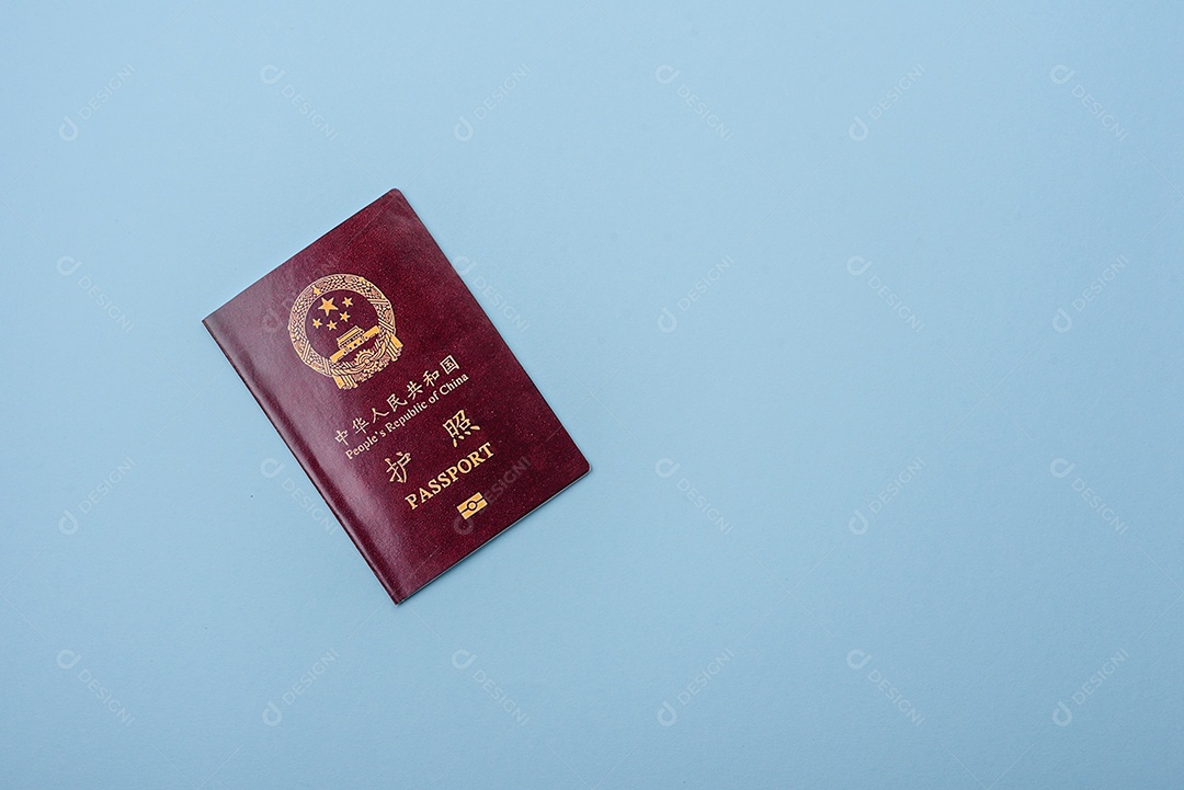 Passaporte internacional em papel físico de um cidadão chinês sobre fundo azul