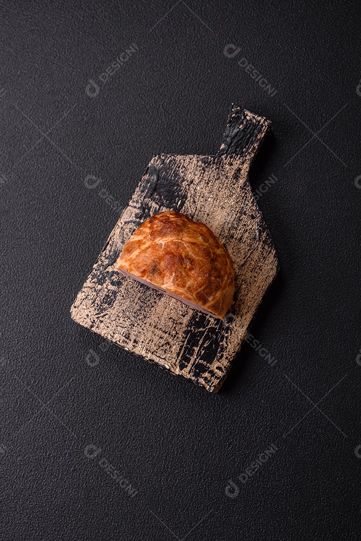 Bolo de carne defumado ou salsicha com sal, especiarias e ervas sobre um fundo escuro de concreto
