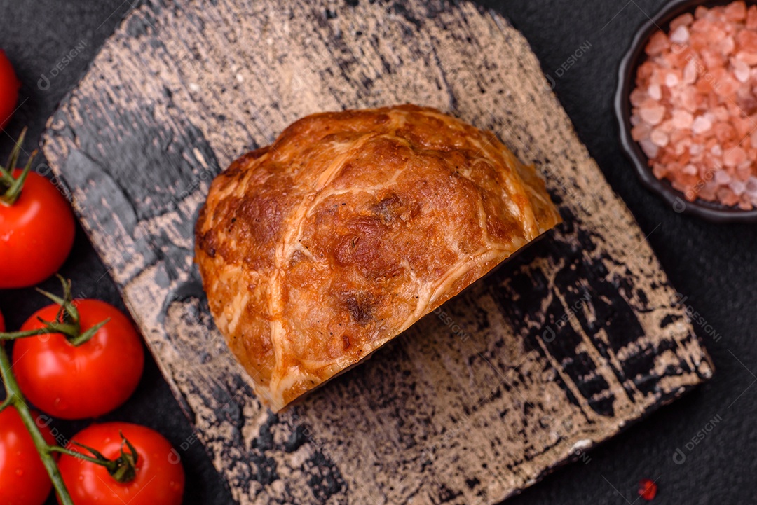 Bolo de carne defumado ou salsicha com sal, especiarias e ervas sobre um fundo escuro de concreto