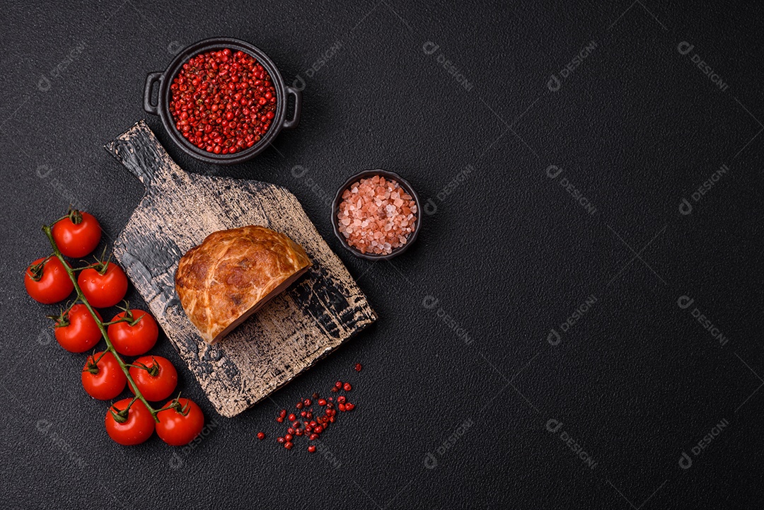 Bolo de carne defumado ou salsicha com sal, especiarias e ervas sobre um fundo escuro de concreto