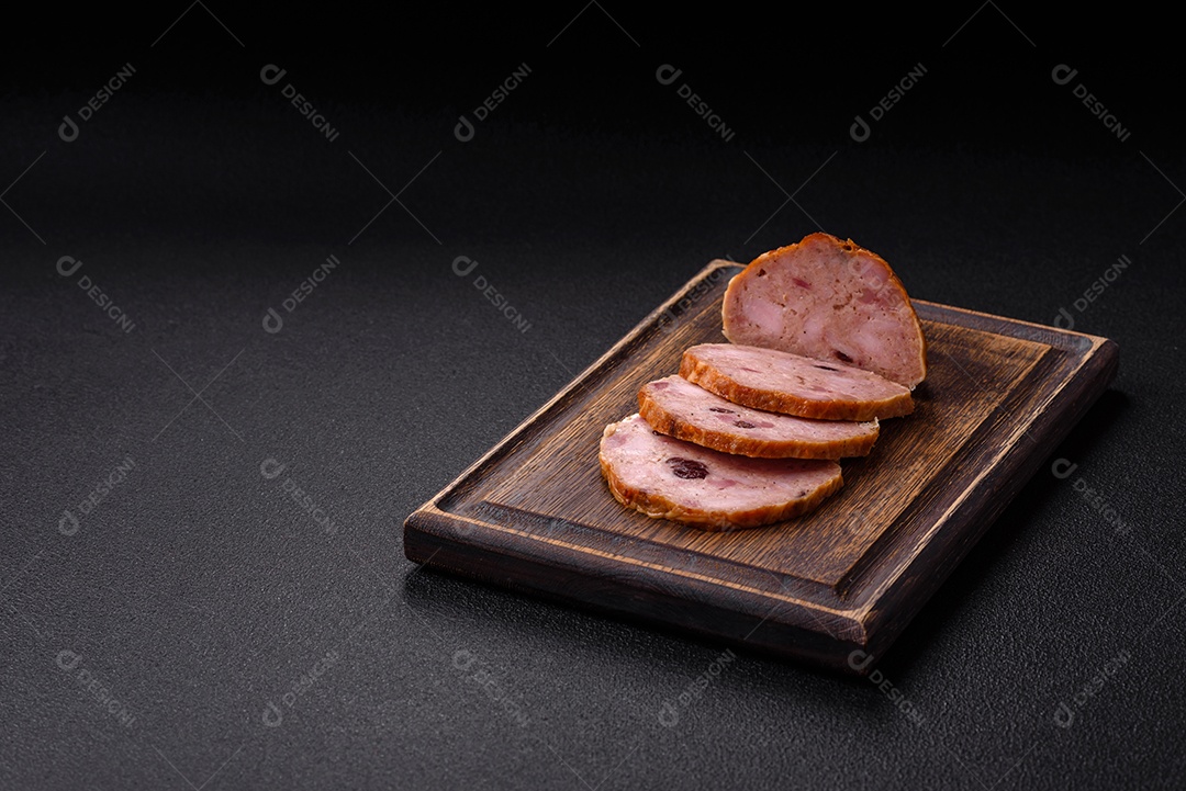 Bolo de carne defumado ou salsicha com sal, especiarias e ervas sobre um fundo escuro de concreto