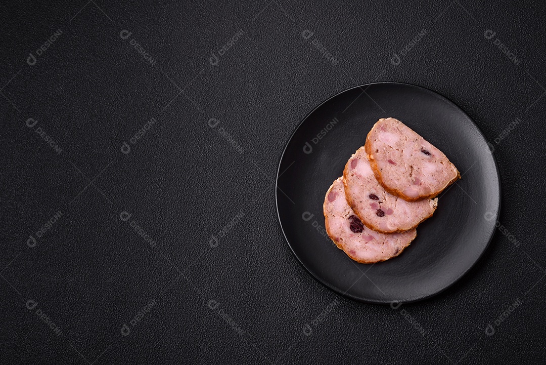 Bolo de carne defumado ou salsicha com sal, especiarias e ervas sobre um fundo escuro de concreto