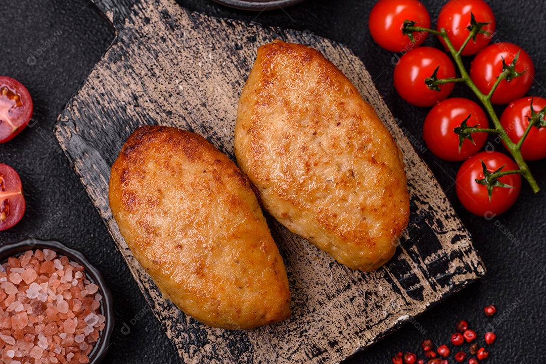 Deliciosas costeletas de peixe picado frito fresco com especiarias e ervas sobre um fundo escuro de concreto