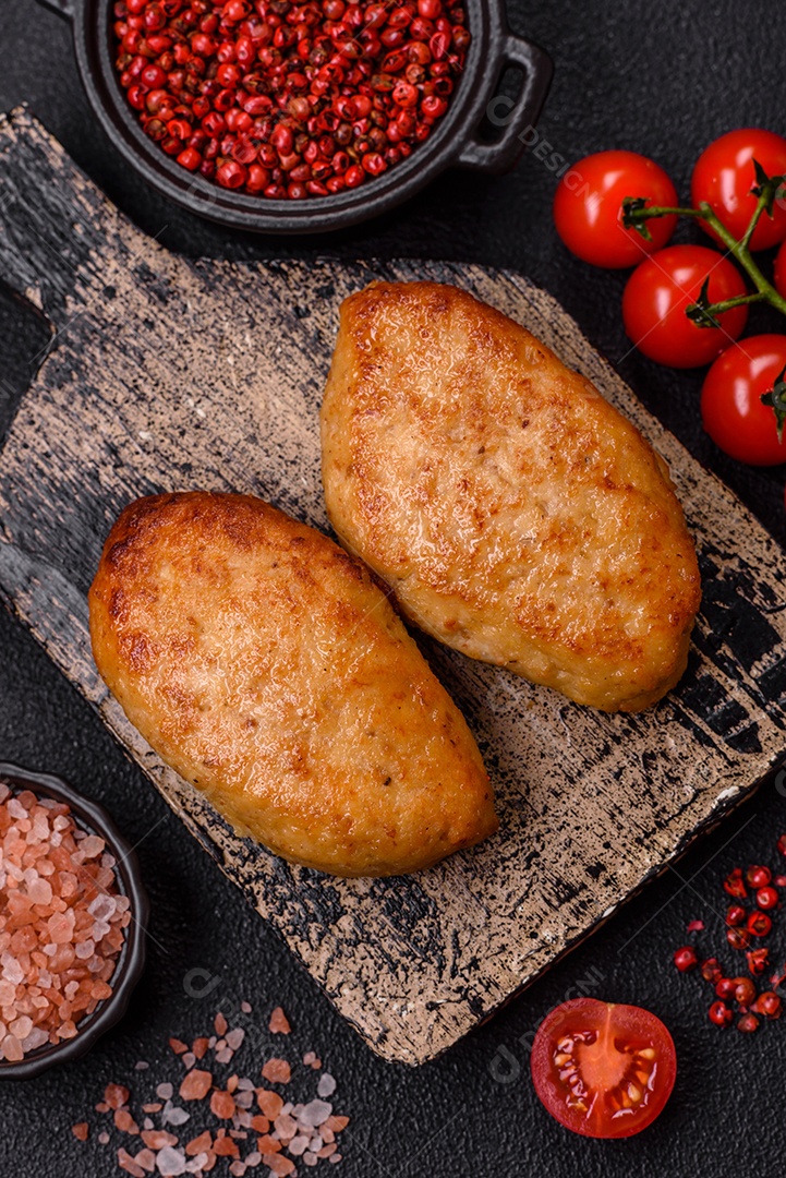 Deliciosas costeletas de peixe picado frito fresco com especiarias e ervas sobre um fundo escuro de concreto
