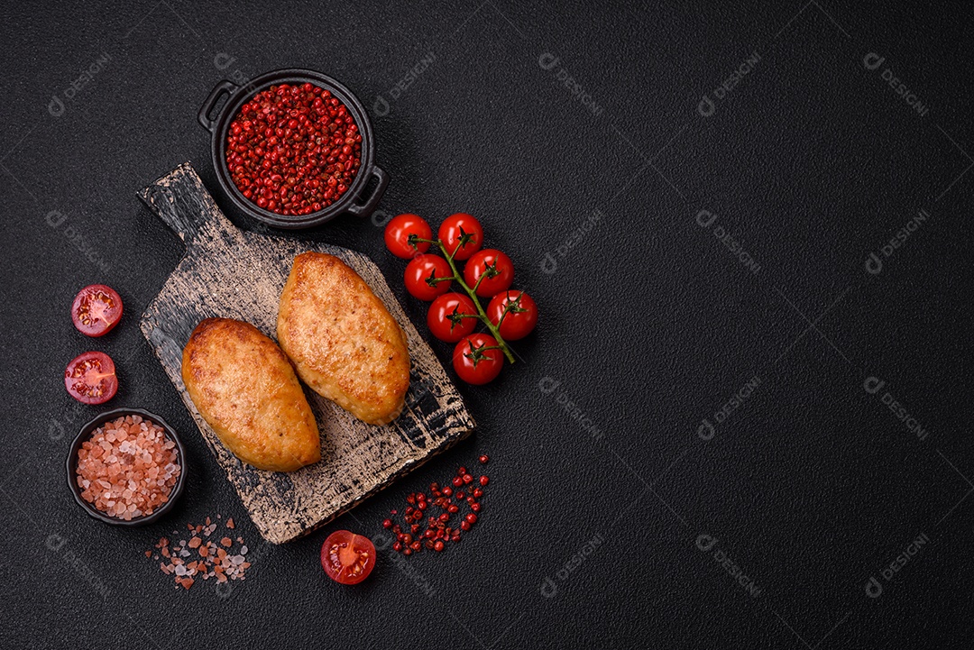 Deliciosas costeletas de peixe picado frito fresco com especiarias e ervas sobre um fundo escuro de concreto