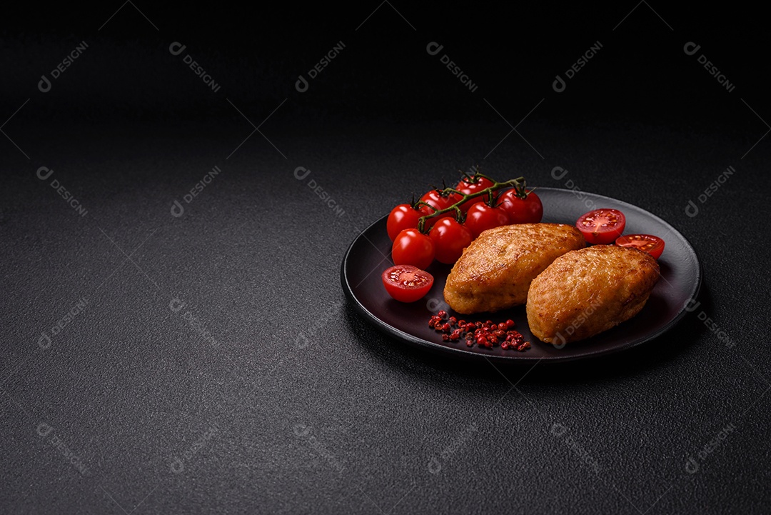 Deliciosas costeletas de peixe picado frito fresco com especiarias e ervas sobre um fundo escuro de concreto