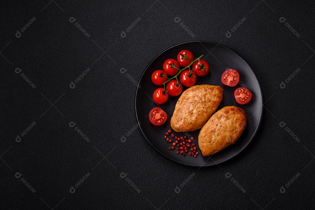 Deliciosas costeletas de peixe picado frito fresco com especiarias e ervas sobre um fundo escuro de concreto