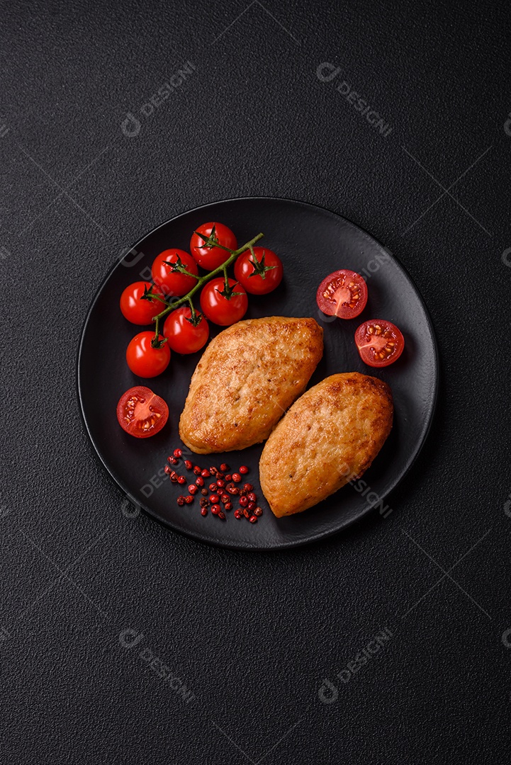 Deliciosas costeletas de peixe picado frito fresco com especiarias e ervas sobre um fundo escuro de concreto