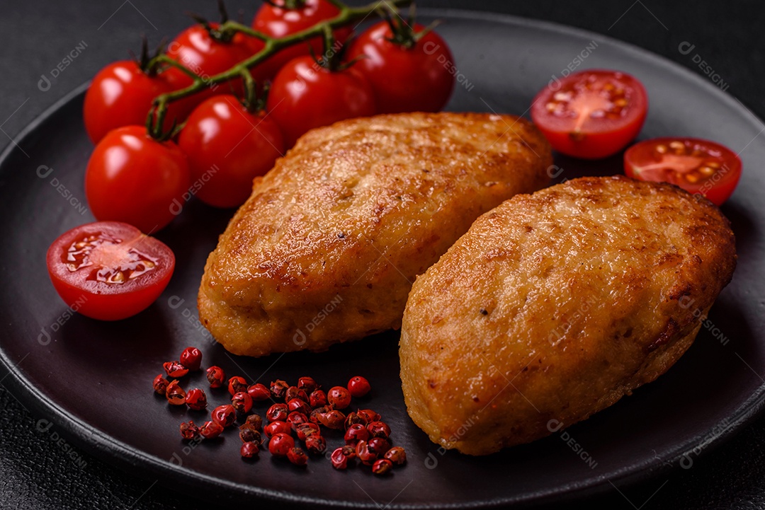 Deliciosas costeletas de peixe picado frito fresco com especiarias e ervas sobre um fundo escuro de concreto