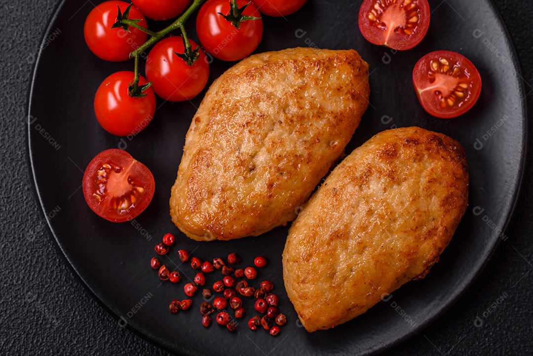 Deliciosas costeletas de peixe picado frito fresco com especiarias e ervas sobre um fundo escuro de concreto