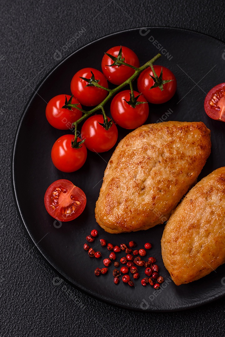 Deliciosas costeletas de peixe picado frito fresco com especiarias e ervas sobre um fundo escuro de concreto