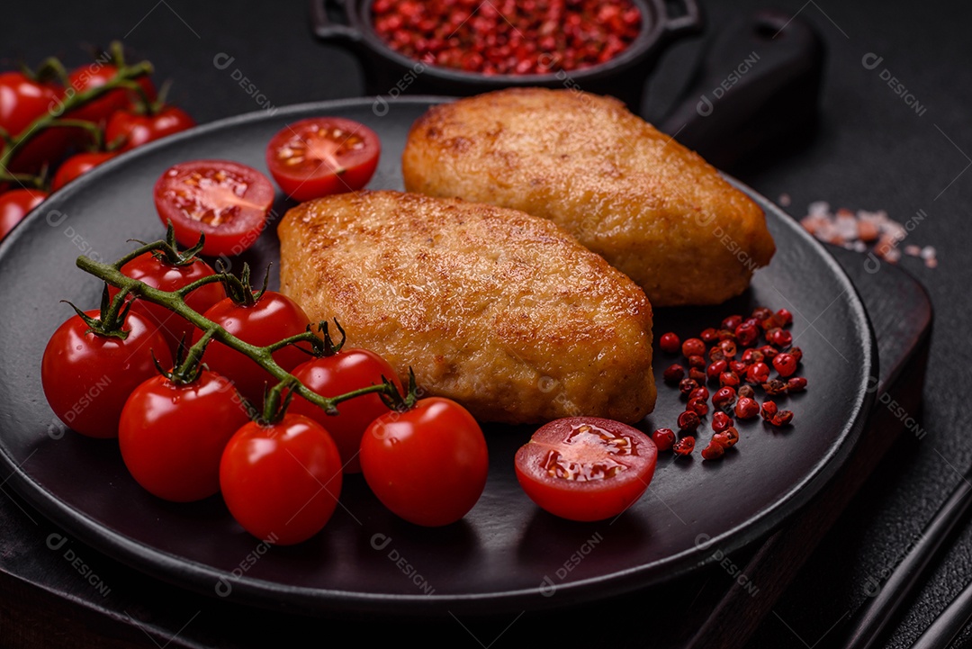 Deliciosas costeletas de peixe picado frito fresco com especiarias e ervas sobre um fundo escuro de concreto