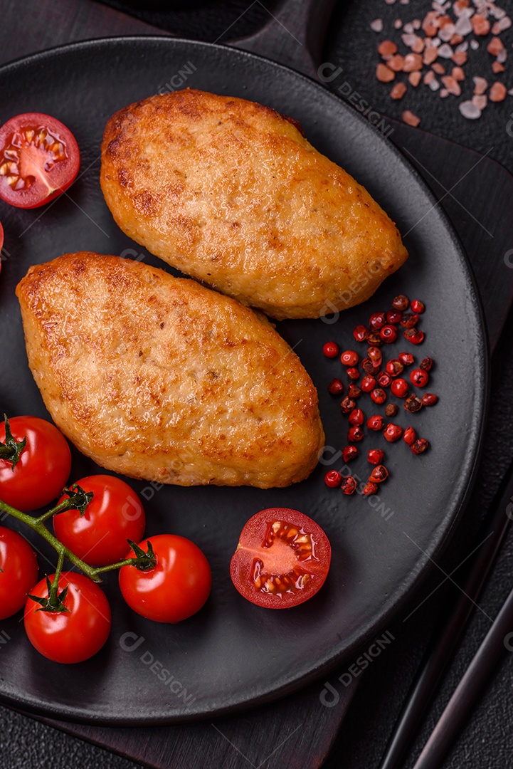 Deliciosas costeletas de peixe picado frito fresco com especiarias e ervas sobre um fundo escuro de concreto