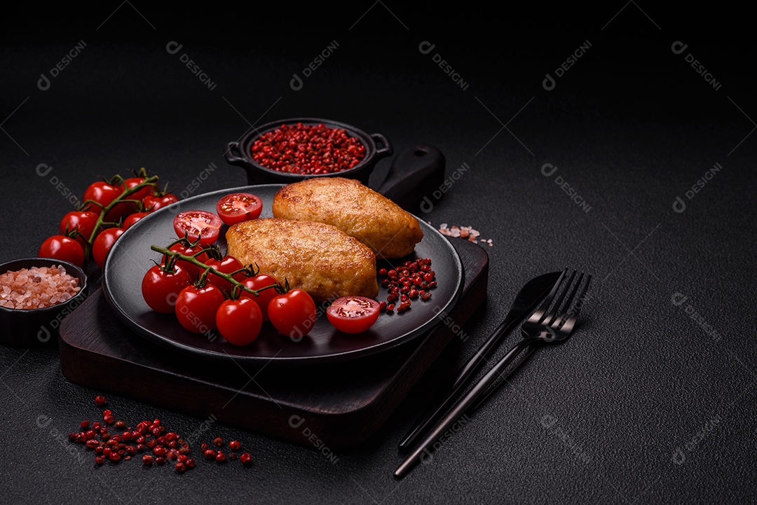 Deliciosas costeletas de peixe picado frito fresco com especiarias e ervas sobre um fundo escuro de concreto