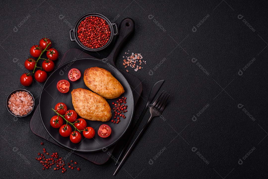 Deliciosas costeletas de peixe picado frito fresco com especiarias e ervas sobre um fundo escuro de concreto