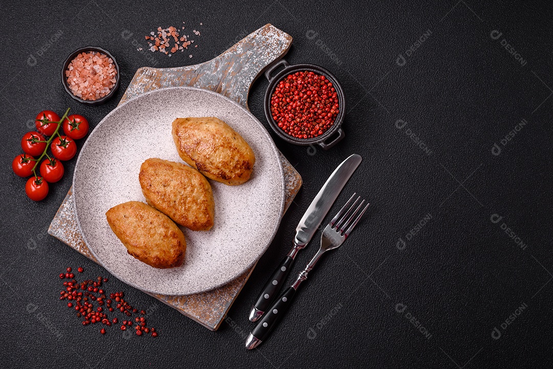 Deliciosas costeletas de peixe picado frito fresco com especiarias e ervas sobre um fundo escuro de concreto